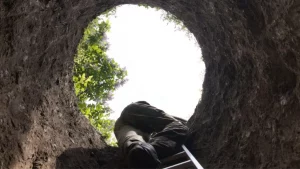 Person climbing out of a hole metaphor for climbing out of debt